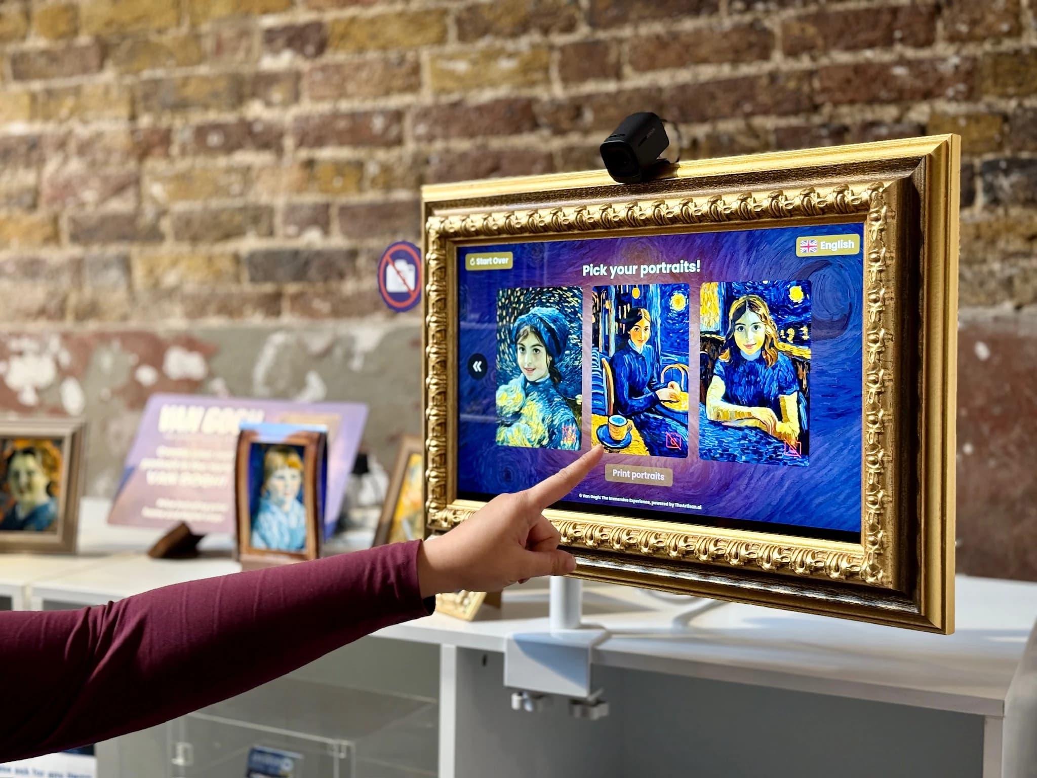 A visitor choosing a portrait on the framed touchscreen at the Van Gogh experience