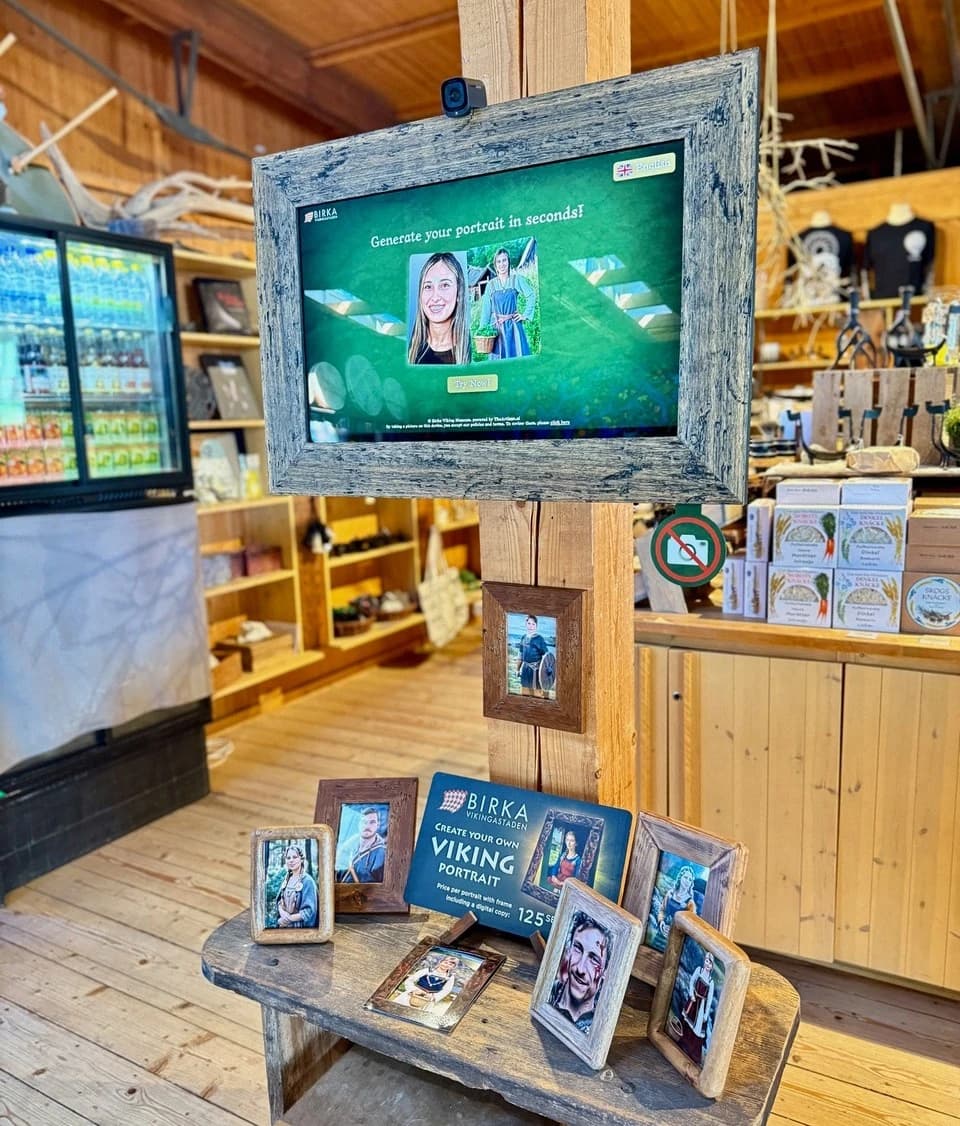 A timber-framed portrait kiosk and Viking souvenir display at Birka