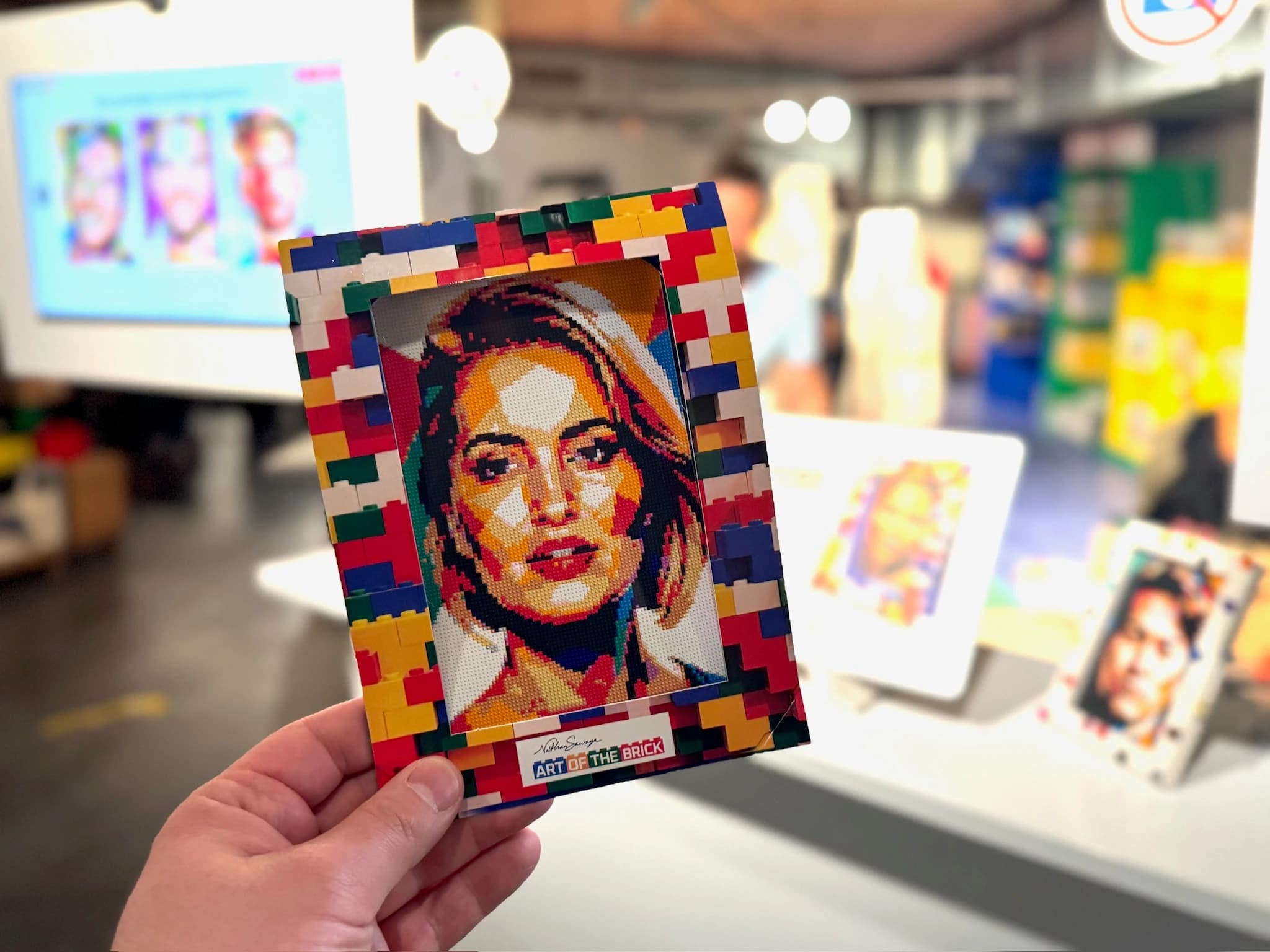A guest holding a brick-style framed portrait souvenir